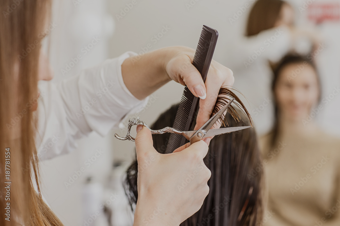 Coiffeuse en train de coiffer une cliente